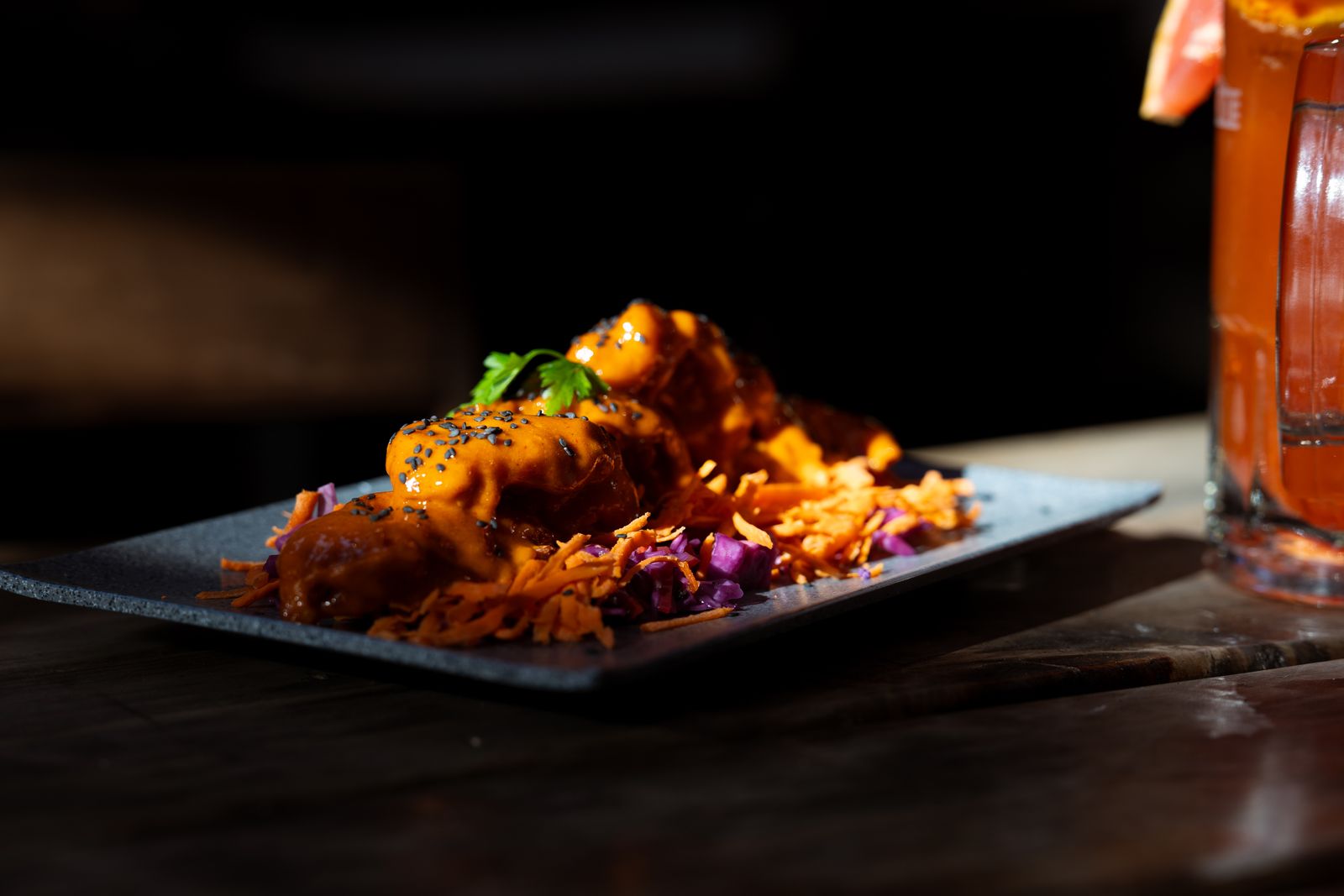 A plated gourmet dish paired with a craft cocktail in an elegant restaurant setting