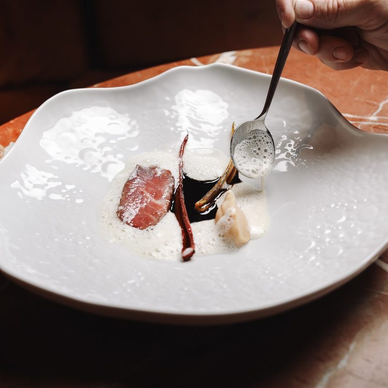 Plated dish at VIBE by Mattia Stanchieri being finished tableside