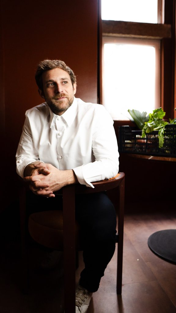 Mattia Stanchieri photographed in natural window light in a calm Lisbon interior, with fresh produce nearby