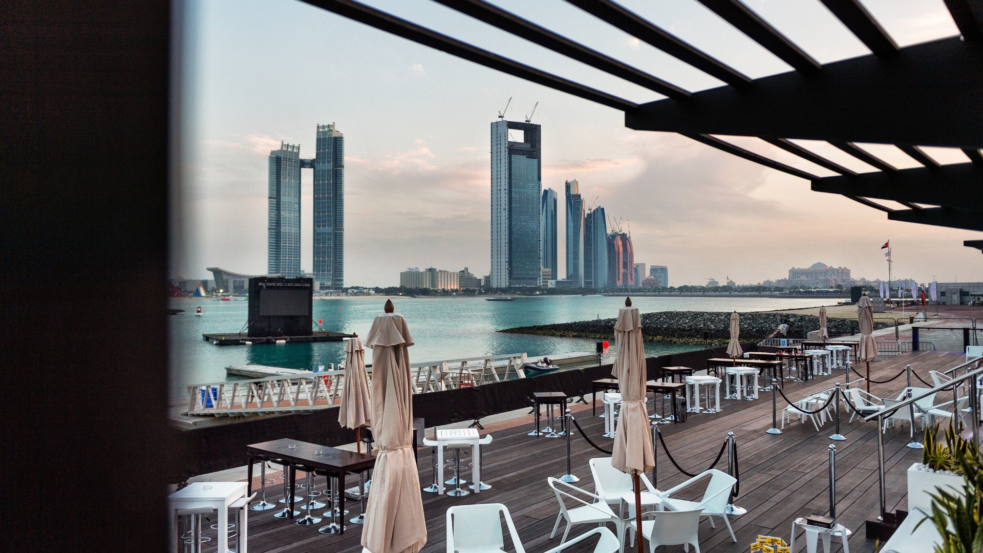 Waterfront restaurant terrace overlooking Abu Dhabi skyline at golden hour