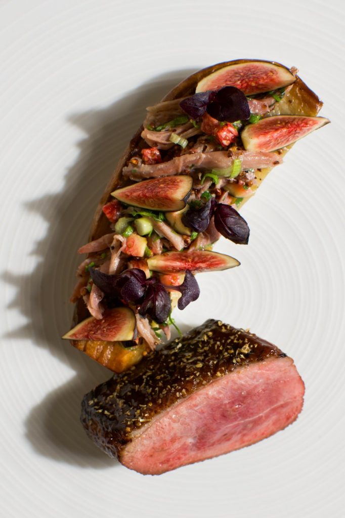 A sliced plated main course photographed on a white plate.