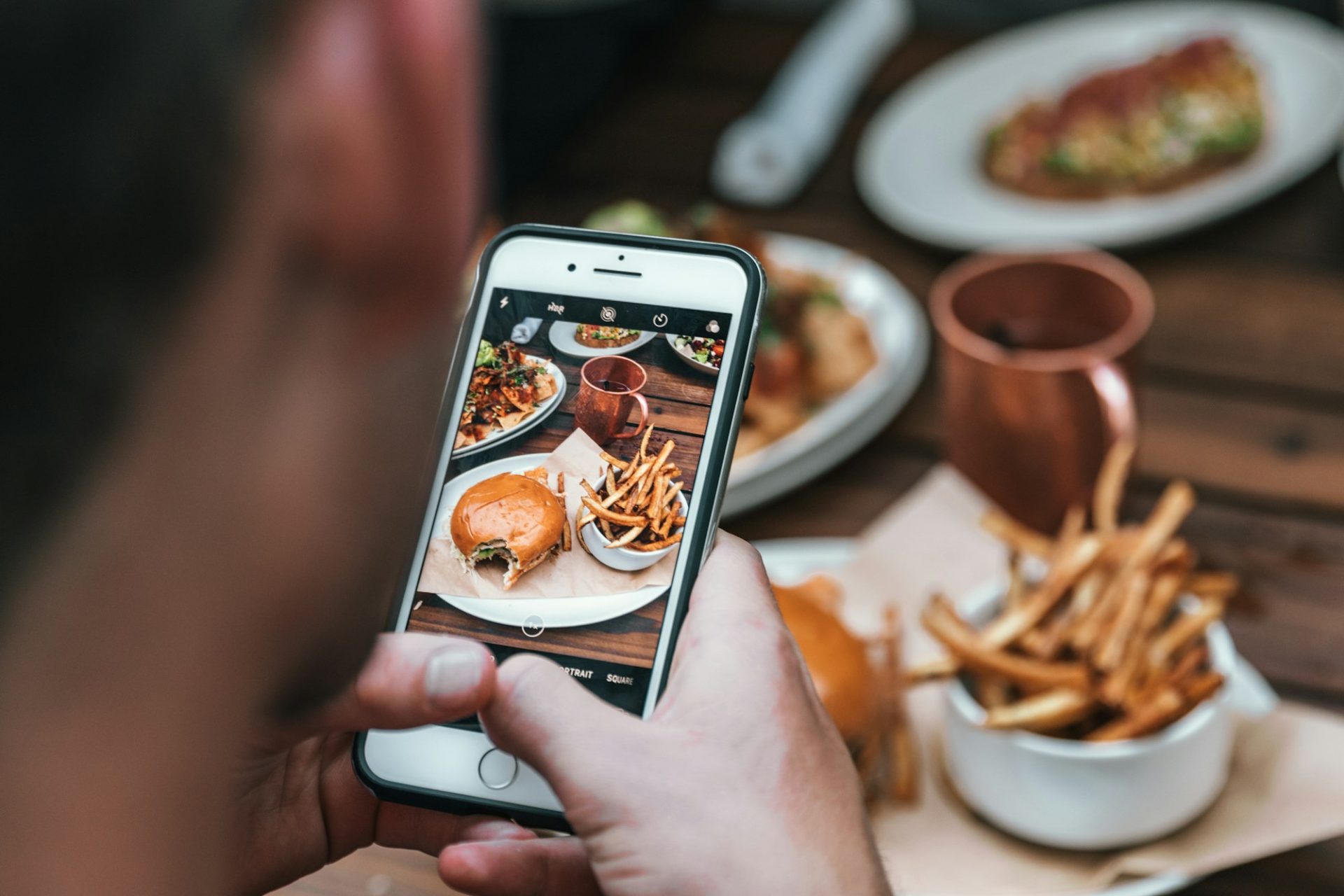 Smartphone capturing a restaurant meal at the table